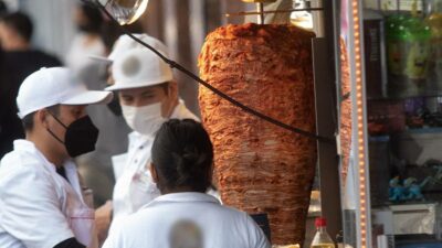 Taquero lava trapeador en comal de puesto callejero en CDMX