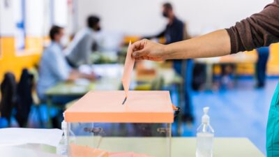 Elecciones España: Persona metiendo su voto en una urna