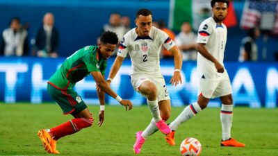 Jugadores de Estados Unidos y México disputan el balón en partido de la Concacaf