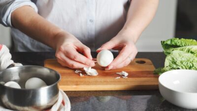 Persona quitando la cáscara a un huevo hervido