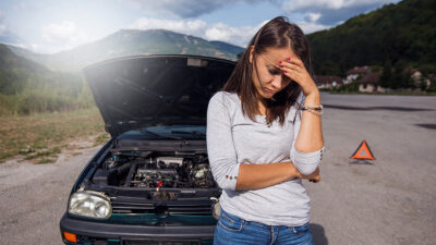 Calor automóviles: Mujer bajo el rayo del sol sufriendo por su automóvil descompuesto