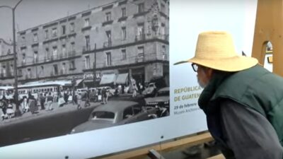 Hombre observado una fotografía en una exposición al aire libre en el Centro Histórico de la Ciudad de México