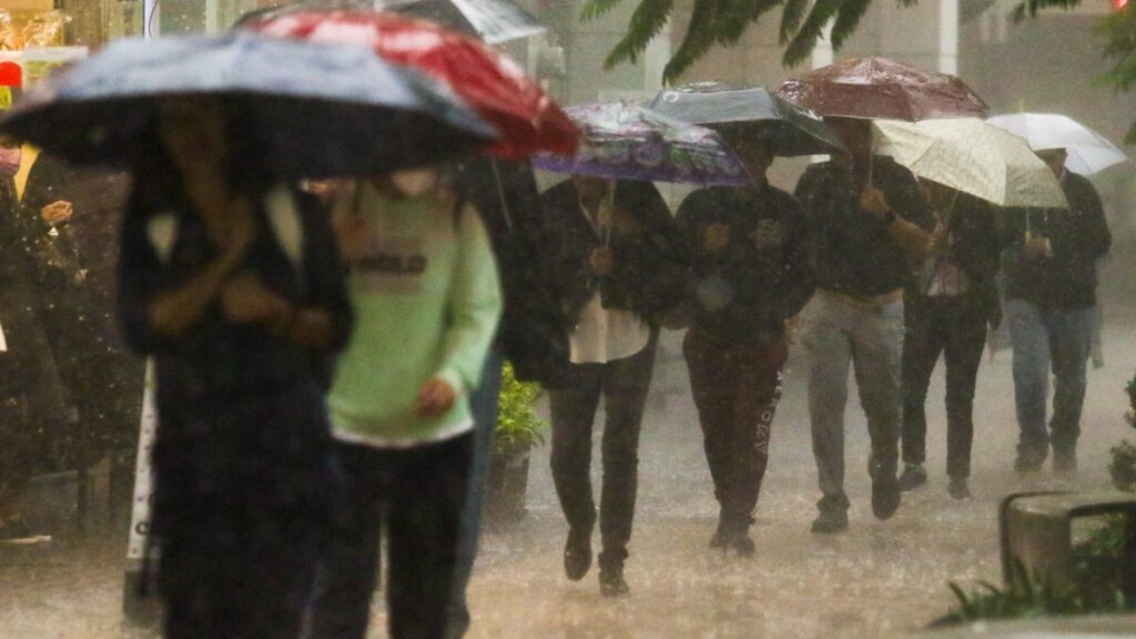 Personas cubriéndose de la lluvia con paraguas en la Ciudad de México