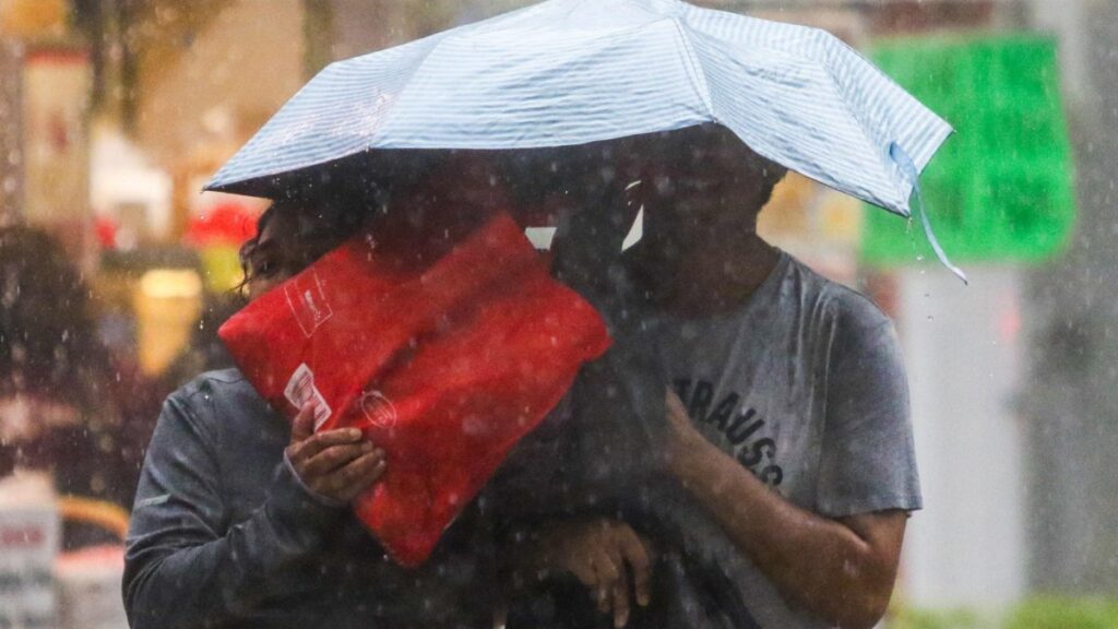 Dos personas se cubren de la lluvia con un paraguas