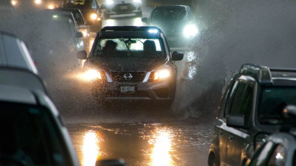 Avenida de la CDMX inundada con carros circulando sobre ella