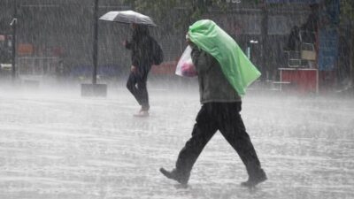 Hombre protegiéndose de la lluvia con un plástico en la cabeza