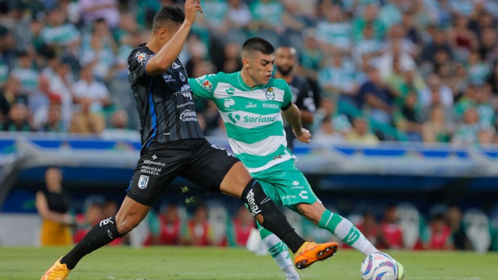 Jugadores del Querétaro y Santos disputan el balón en partido de la Liga MX