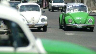 Vochos taxis circulando por una calle de la Ciudad de México