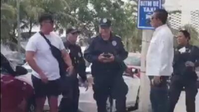 Taxista increpa a chofer de Uber ante la mirada de policías en Cancún, Quintana Roo