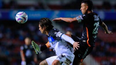 Jugadores de Querétaro y Pachuca disputan el balón en partido de futbol