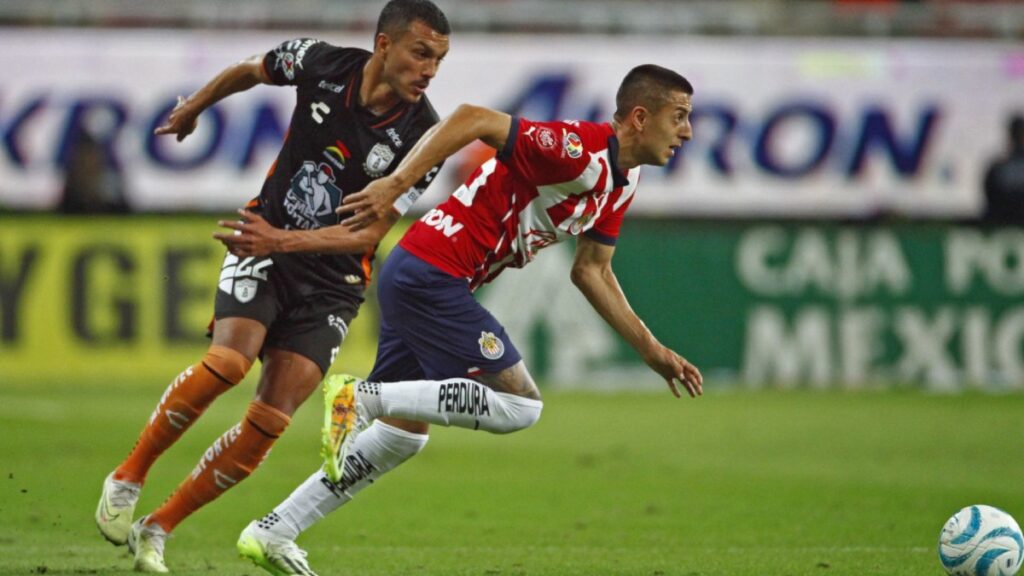 Jugadores de Chivas y Toluca disputan el balón en partido de la Liga MX