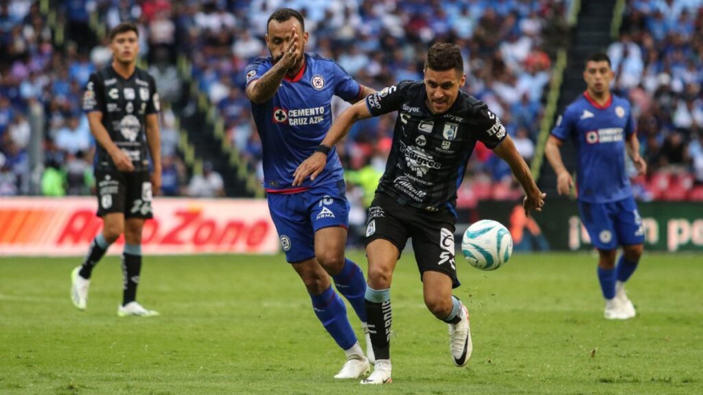 Jugadores de Cruz Azul y Querétaro disputan el balón en el estadio Azteca