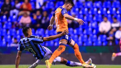 Jugadores del Querétaro y Puebla se enfrentan en partido de futbol