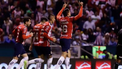 Jugadores de Chivas celebran su triunfo ante Puebla en partido de la Liga MX