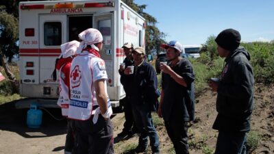 Migrantes conversan con elementos de la Cruz Roja quienes los auxilian en Ciudad Serdán, Puebla
