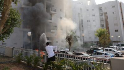 Joven observa cómo se incendia un edificio en Israel