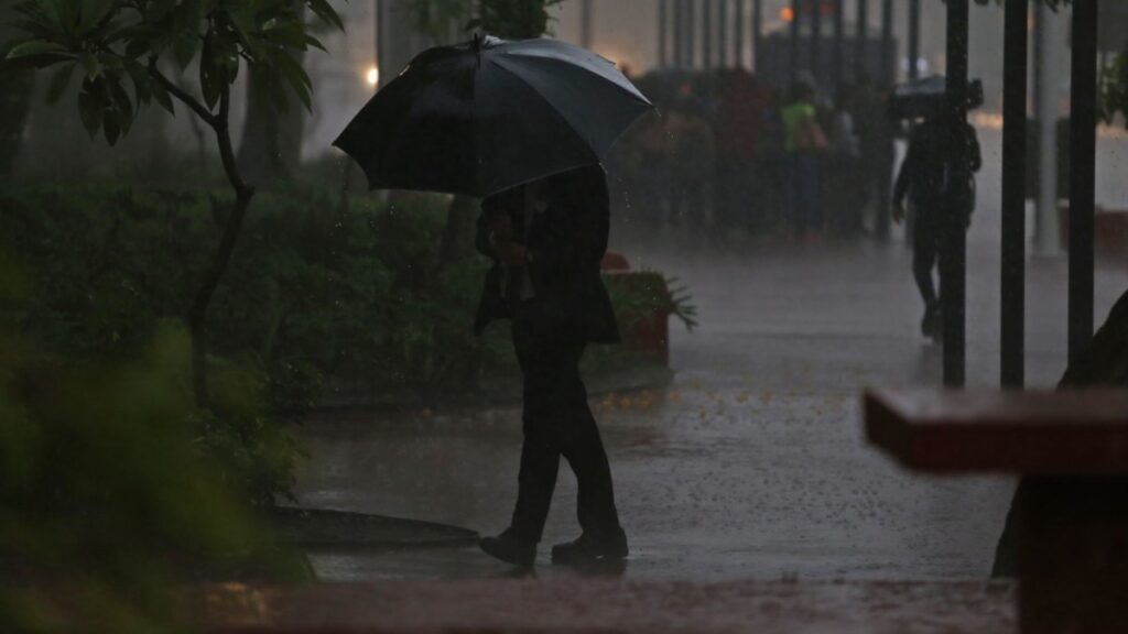 Mujer camina con paraguas bajo una intensa lluvia en México