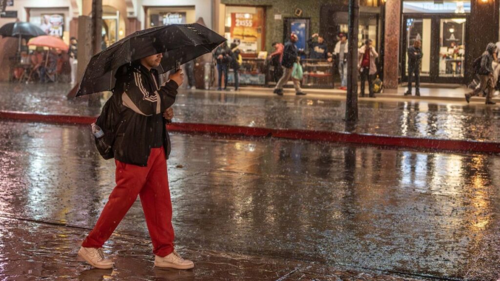 Hombre camina con paraguas bajo la lluvia