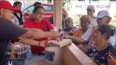 Un hombre entrega comida a pobladores de Acapulco afectados por el huracán Otis