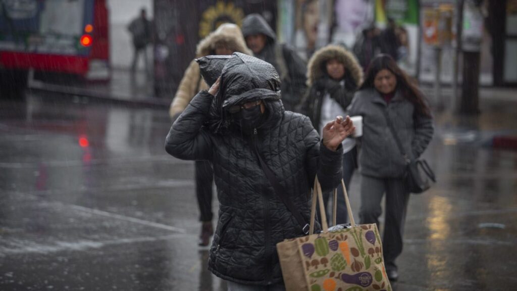 Mujeres caminan por la calle abrigadas ante el frío