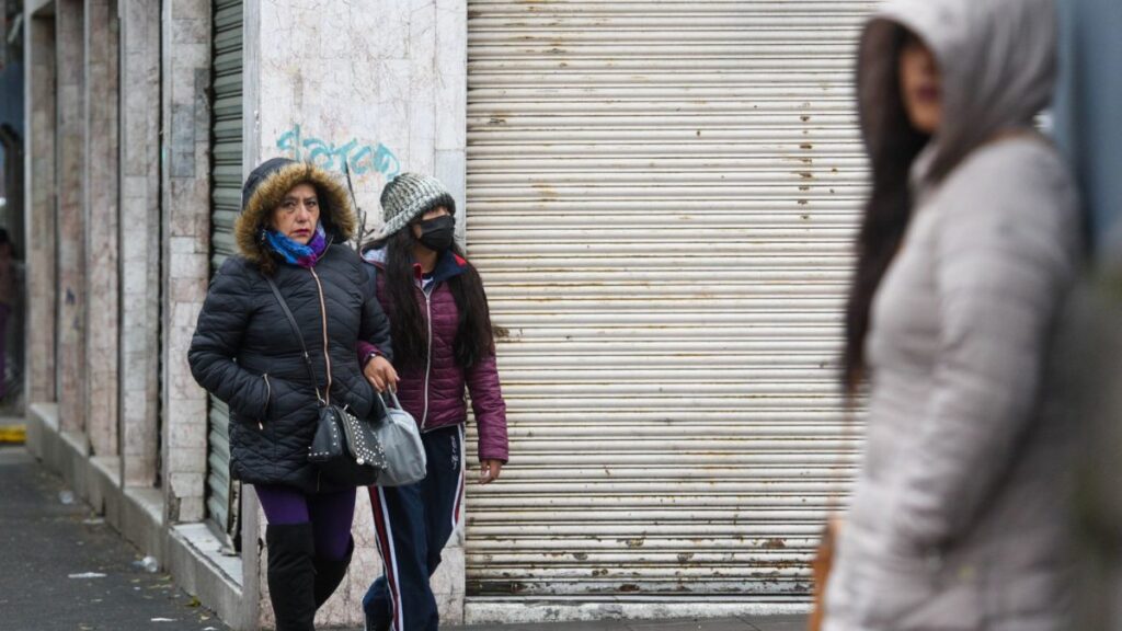 Mujeres en la calle con chamarras y gorro para cubrirse del frío