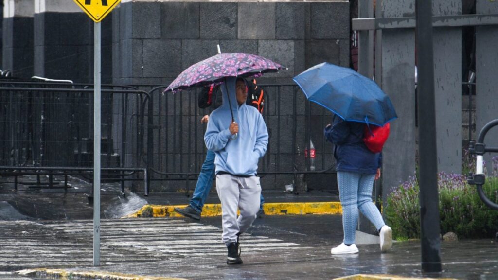 Personas con paraguas caminan en la calle bajo la lluvia