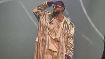 Maluma vestido con un traje metálico gris en un concierto en Las Vegas