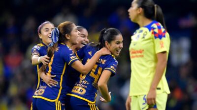 Jugadoras de Tigres festejan su triunfo ante la mirada de una jugadora del América en la final de la Liga MX Femenil