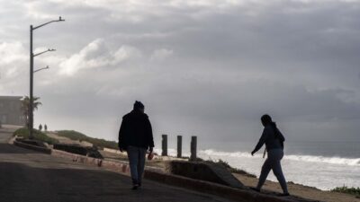 Personas caminando en ambiente frío con el cielo nublado de fondo