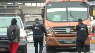 Policías enfrente de un camión de transporte público en la CDMX