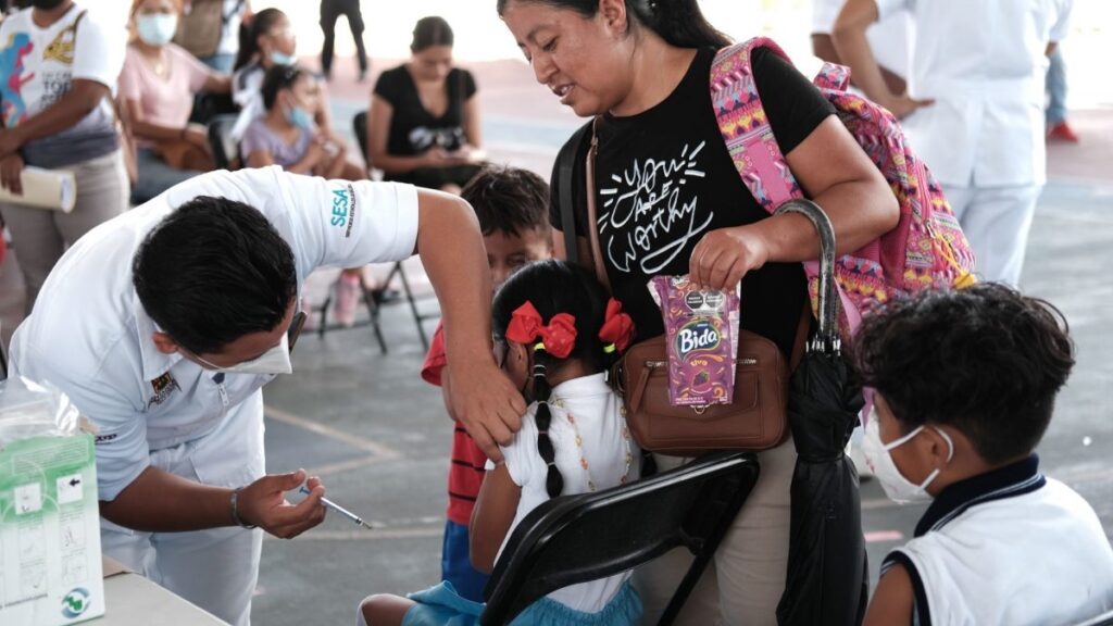 Niña recibiendo la vacuna contra el Covid-19 acompañada de su madre