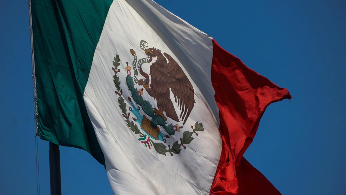 AMLO acepta izar la bandera del Zócalo; las vallas siguen