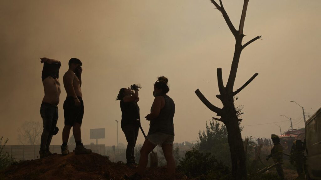 Personas en escombros dejados por los incendios forestales en Chile