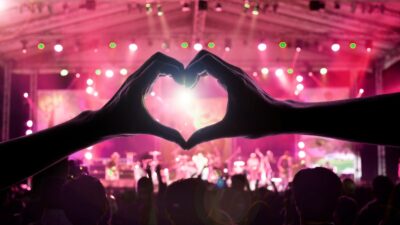 Asistente a concierto hace el símbolo del corazón con las manos
