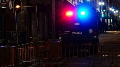 Patrulla circulando con las torretas encendidas en una calle oscura