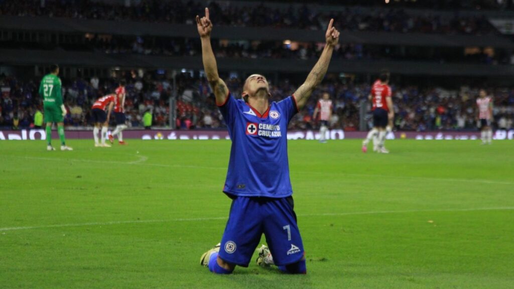 Jugador del Cruz Azul festeja triunfo hincado y con los brazos al cielo en el estadio Azteca