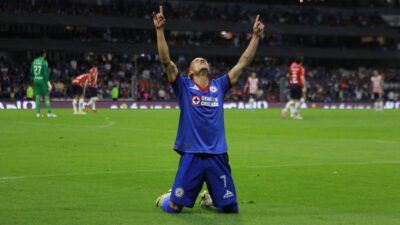 Jugador del Cruz Azul festeja triunfo hincado y con los brazos al cielo en el estadio Azteca