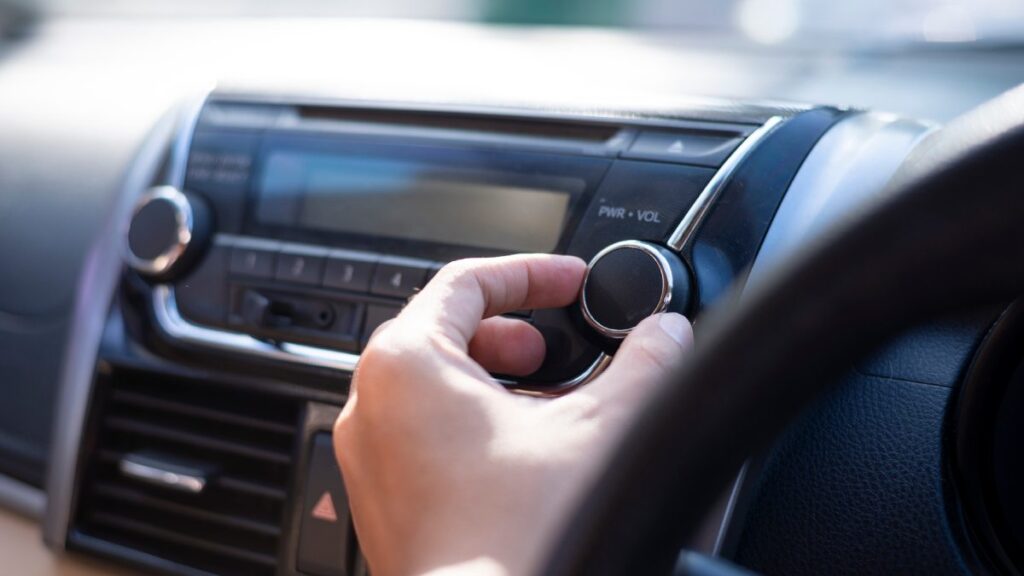 Hombre sube el volumen a la radio en un automóvil