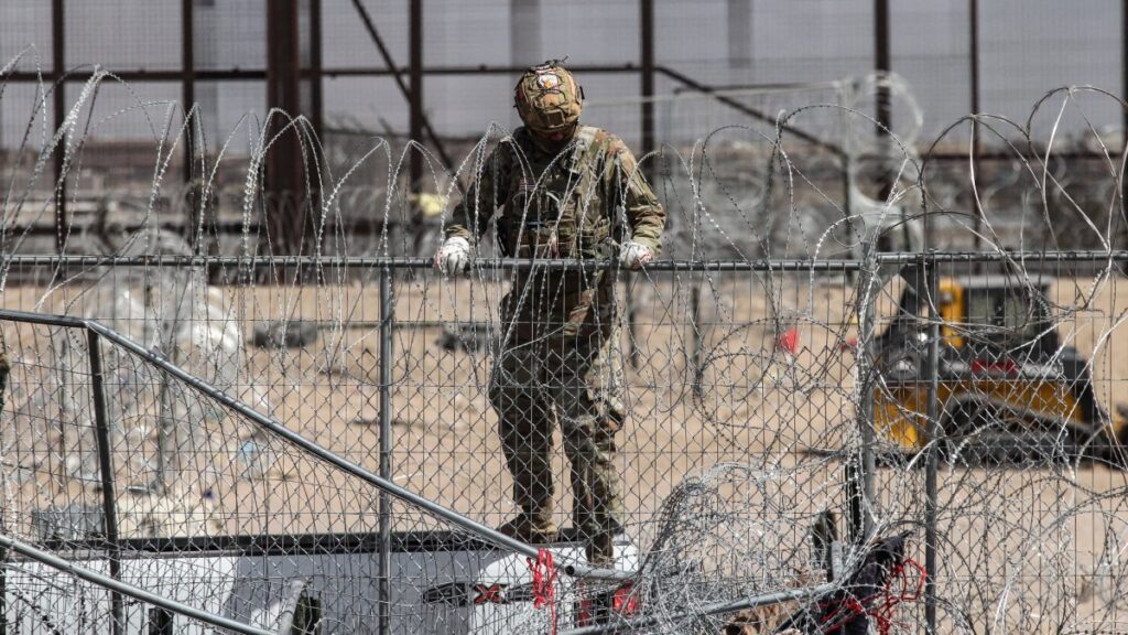 Elemento de la Guardia Nacional de Texas en la malla de alambre de púas que divide México de Estados Unidos en la zona de Texas