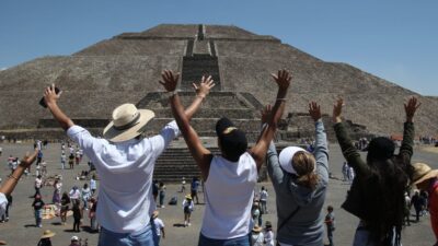 Personas alzando las manos al cielo para recibir a la primavera en Teotihuacán