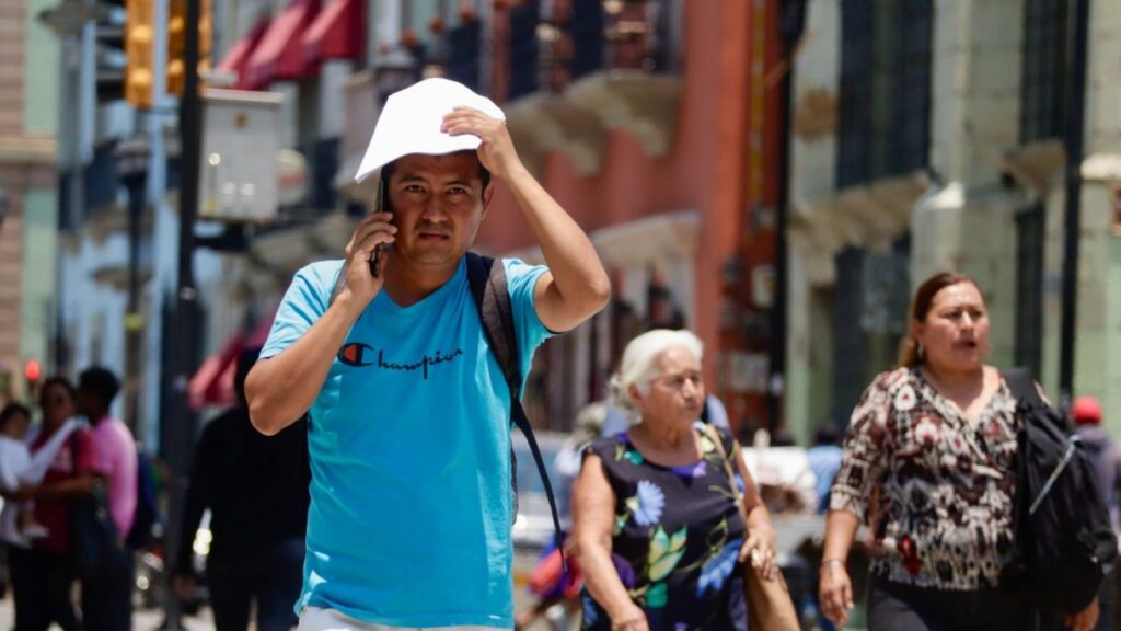 Un hombre se cubre ante la ola de calor en México. Así estará el clima