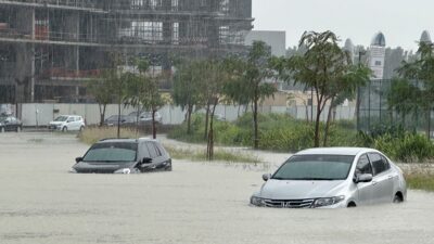 Autos varados en una calle inundada por las lluvias en Dubái