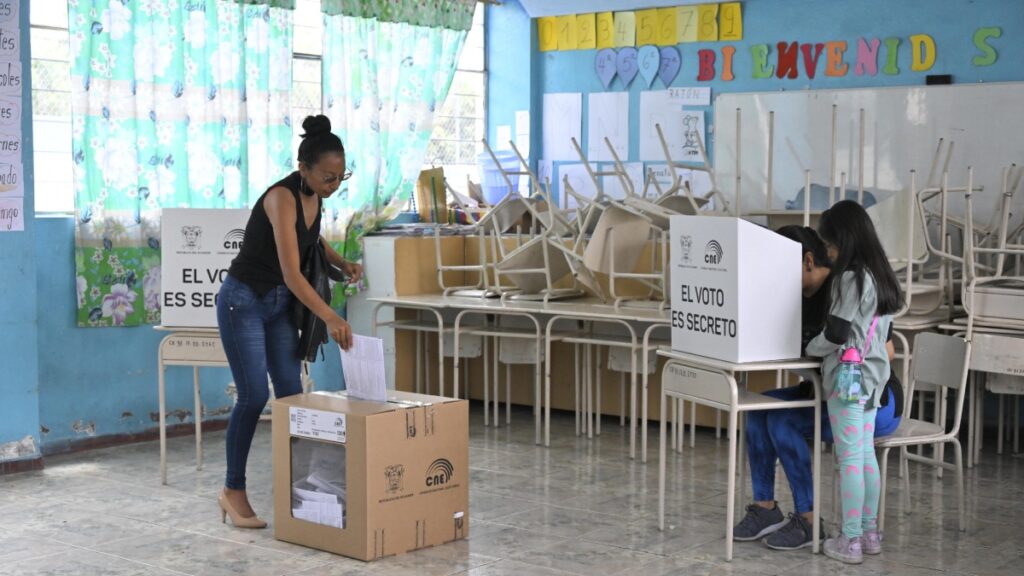 Dos mujeres y una niña en las urnas votando durante el referendo y consulta pública en Ecuador