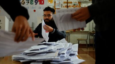 Personas cuentan y acomodan las papeletas tras el referendo y consulta popular en Ecuador
