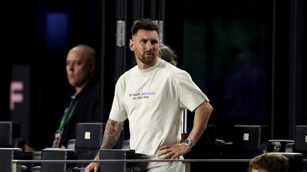 Lionel Messi en un estadio viendo un partido desde las gradas,
