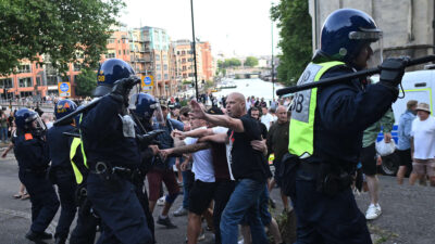 Policía local enfrentando las protestas en el Reino Unido.