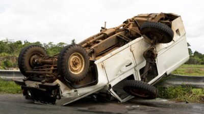 Camioneta cae de puente y queda con llantas arriba.