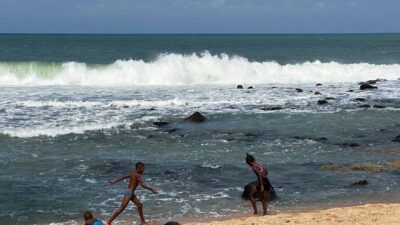 Niños juegan en una playa en Santo Tomé el llamado centro de la tierra