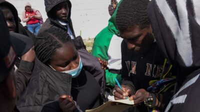 Migrantes en Naucalpan organizan filas en la COMAR para agilizar trámites. Voluntarios asignan turnos y la lista llega hasta marzo.