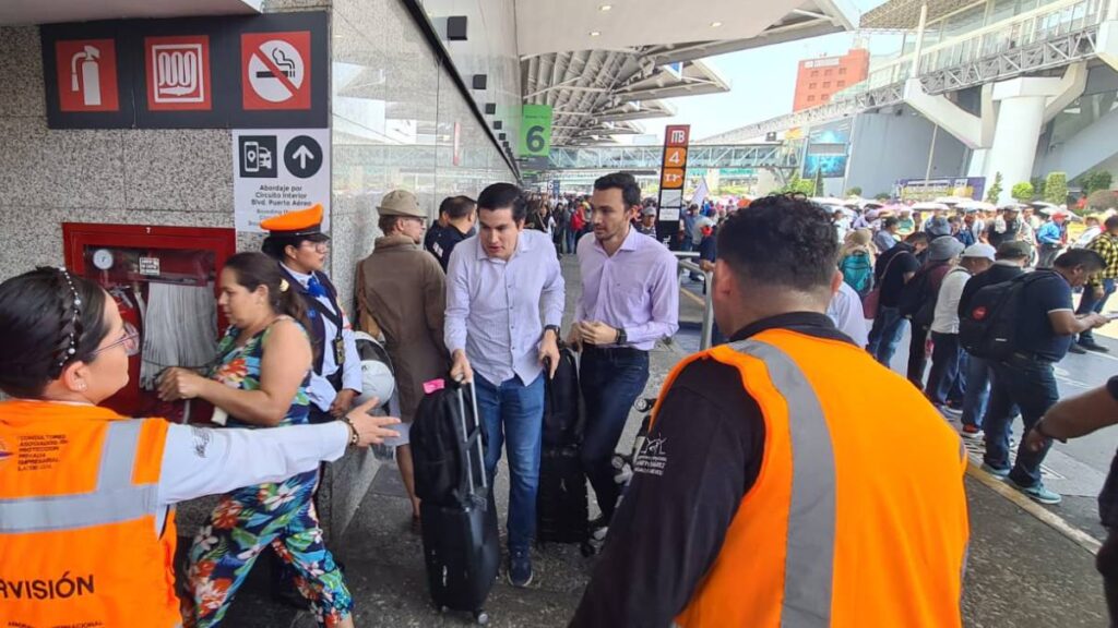 Viajeros ingresan al AICM, atrás maestros de la CNTE.